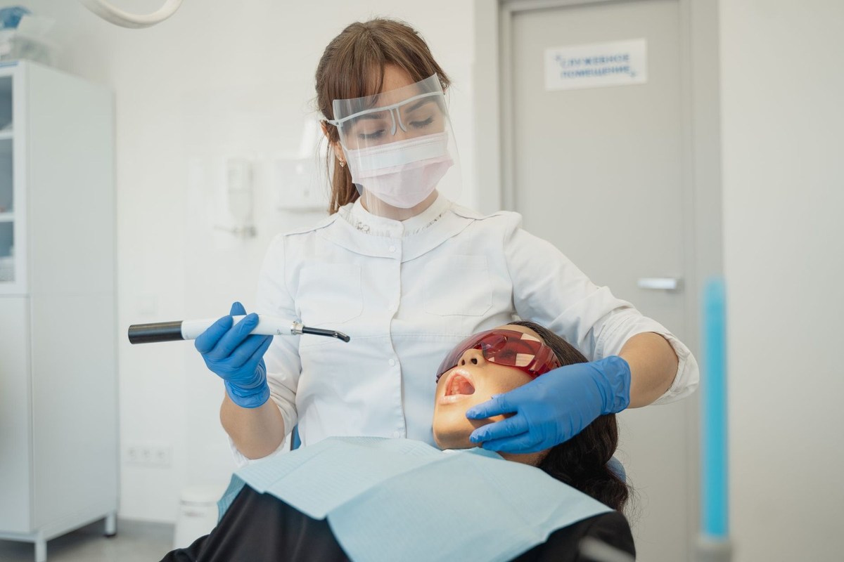Professionnel dentaire inspectant une bouche avec une lampe dans un environnement clinique