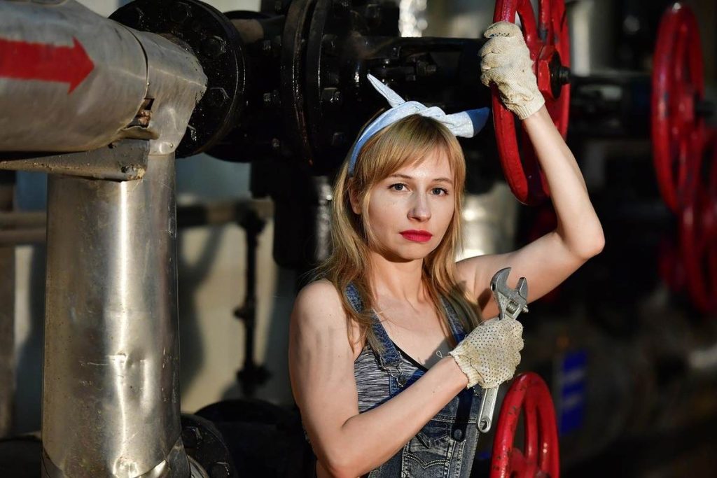 Femme manipulant des manivelles dans un cadre industriel